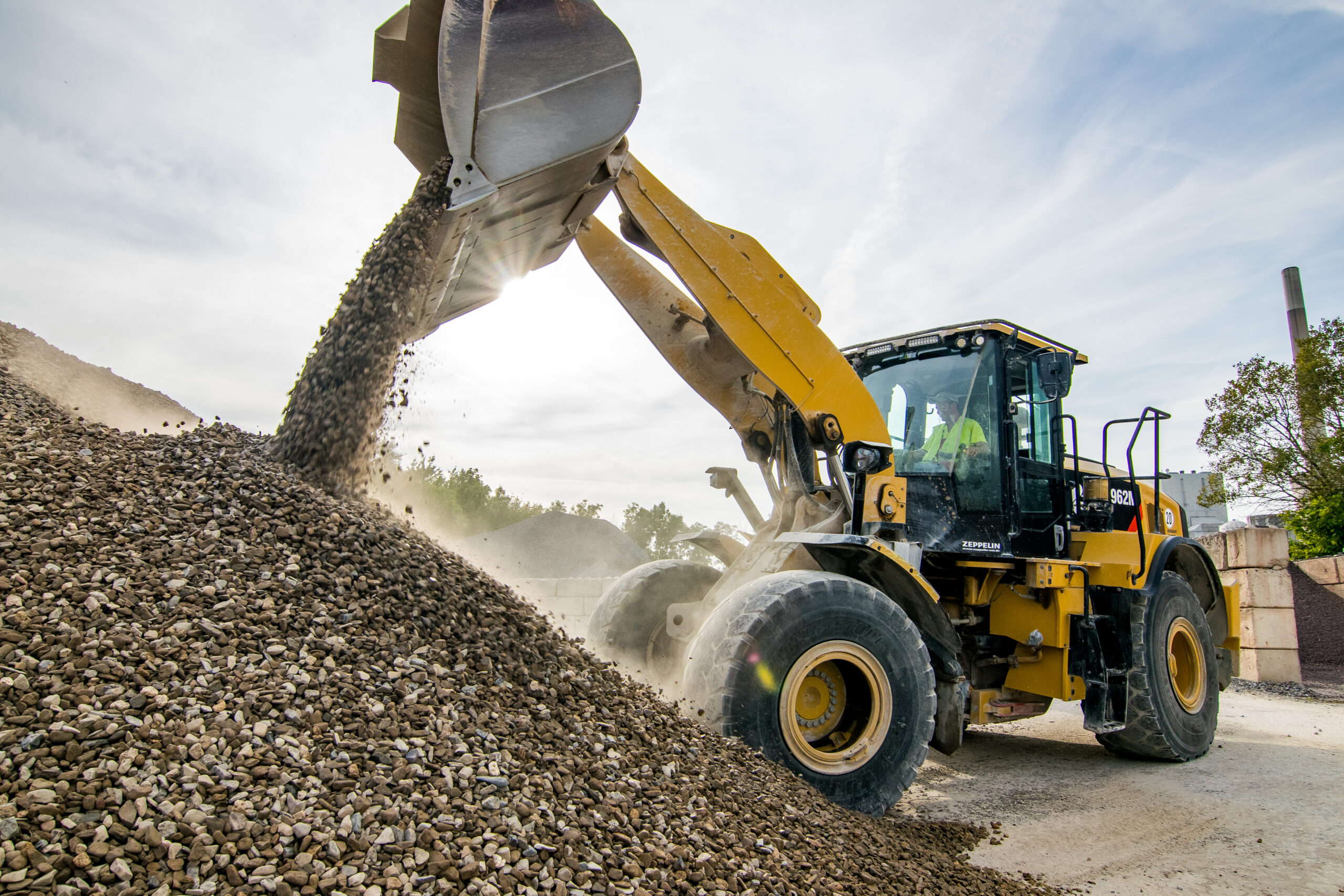 Radlader bei BDB Beton kippt Schüttgut auf einen großen Haufen auf dem Werksgelände